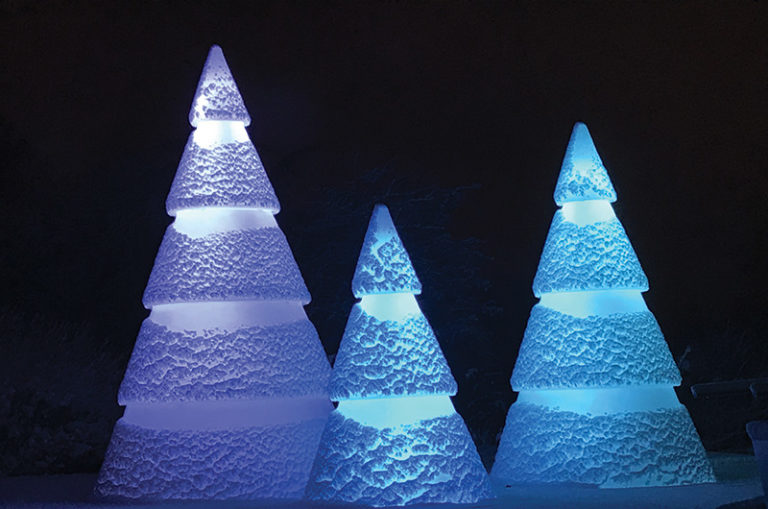 Sapins lumineux sous la neige dans la nuit