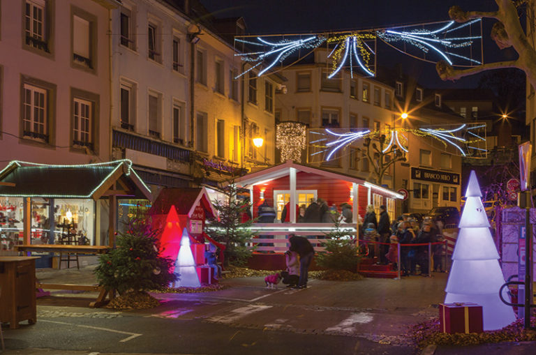 Sapin de Noel lumineux sous la neige au marché de Noel